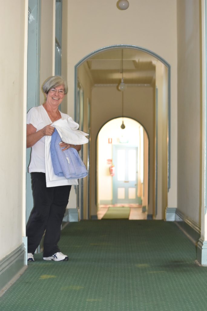 Barbara Beggs stands in an upstairs hallway of the Criterion Hotel where staff have experienced changes in temperature and heard children laughing.